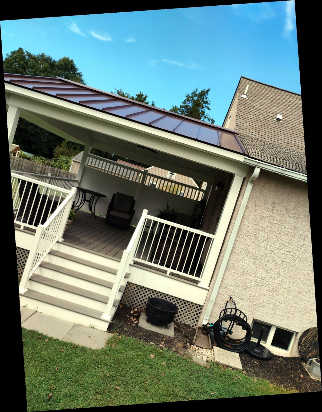 Finished covered porch with white railings and broad steps