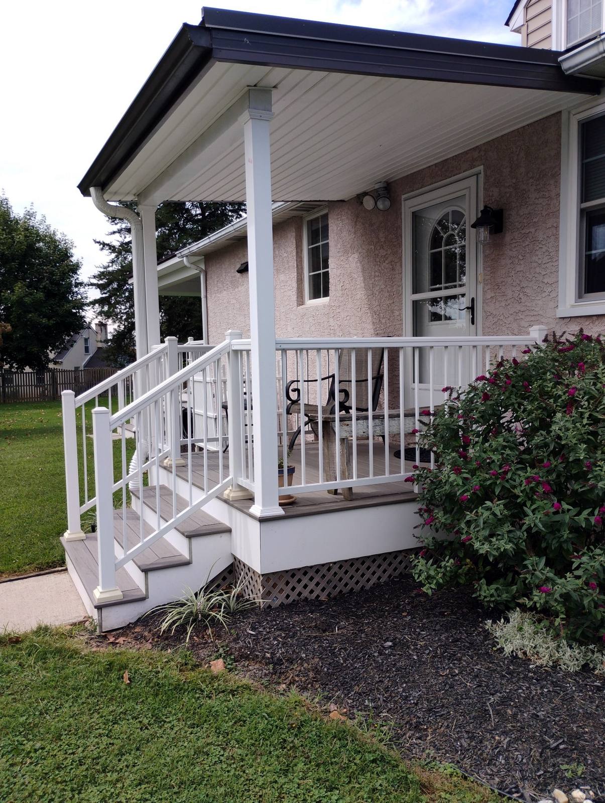 Small finished porch with white vinyl railings
