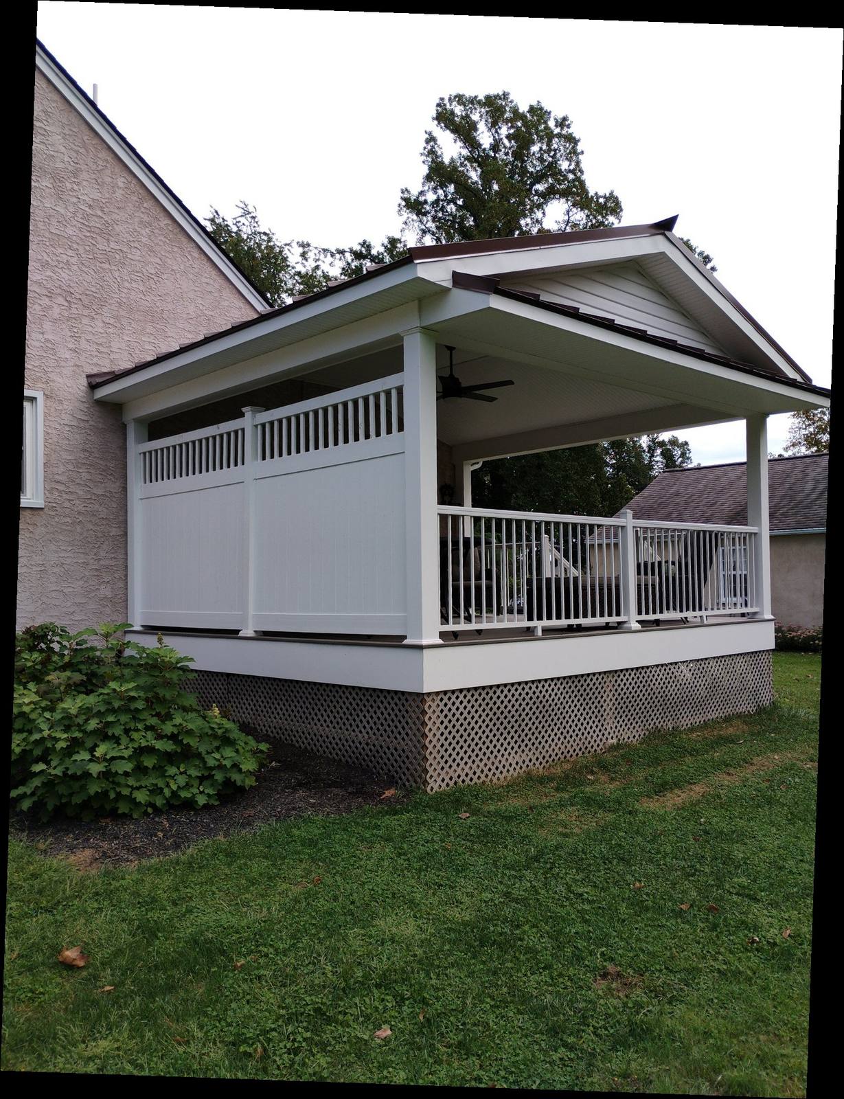 Finished covered porch with white privacy wall and railing