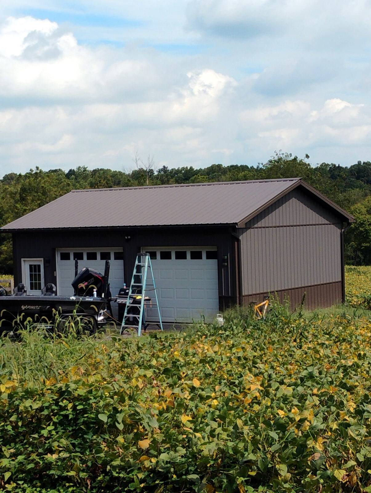 Dark metal garage and workshop with two overhead doors