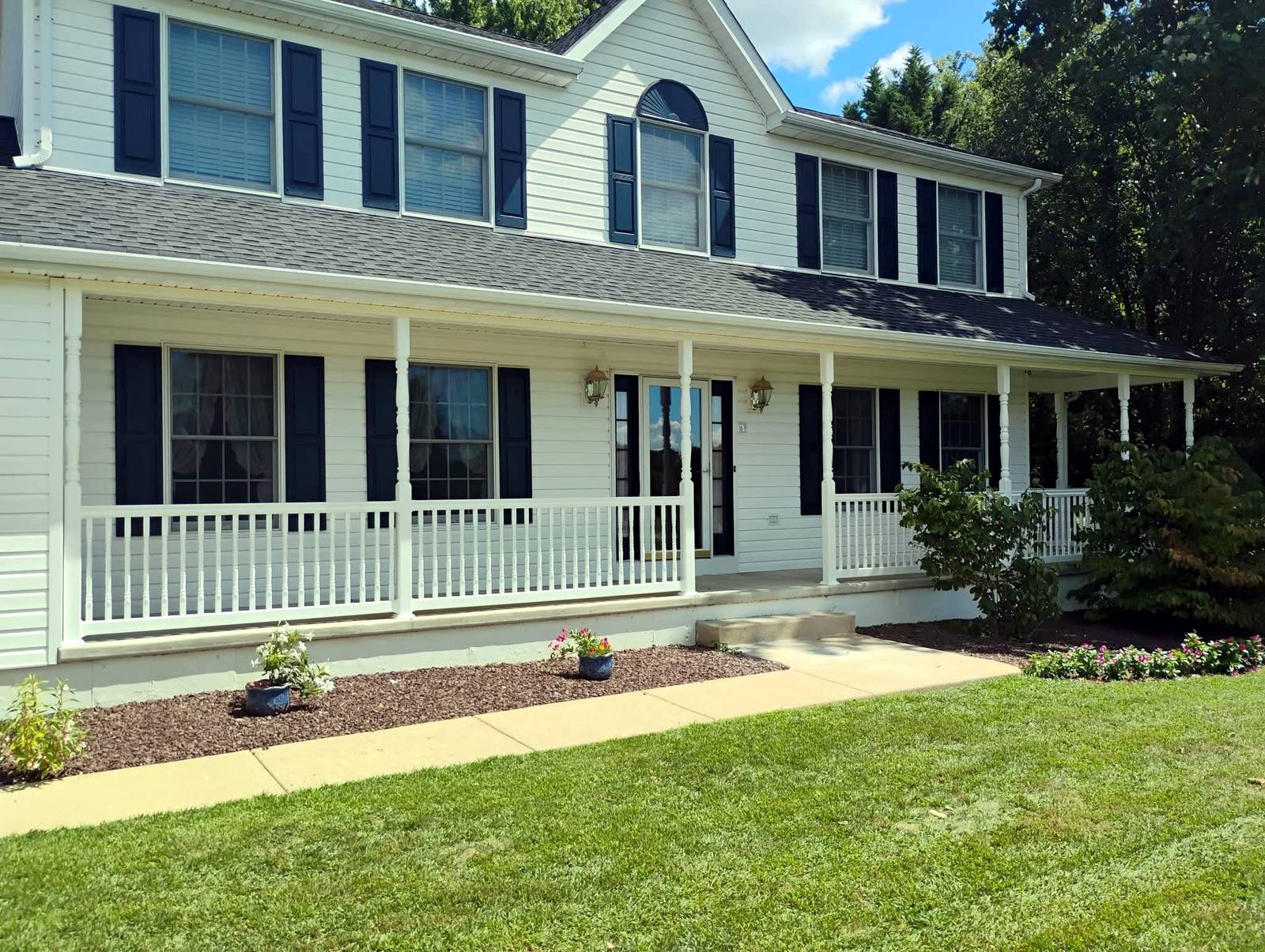 Completed screened porch across the rear of a white home