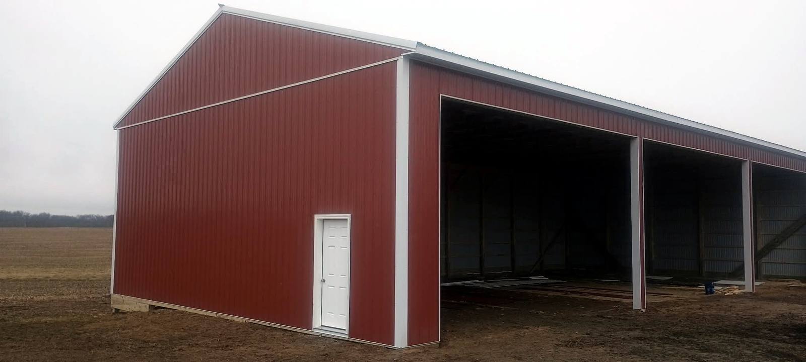 Red open-sided agricultural pole building
