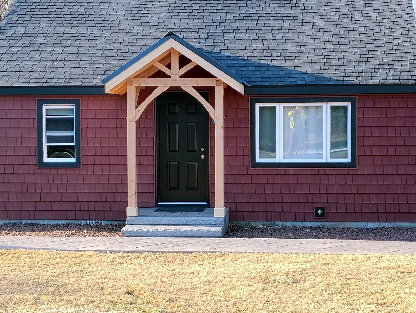 Timber-framed front entry on a finished red home