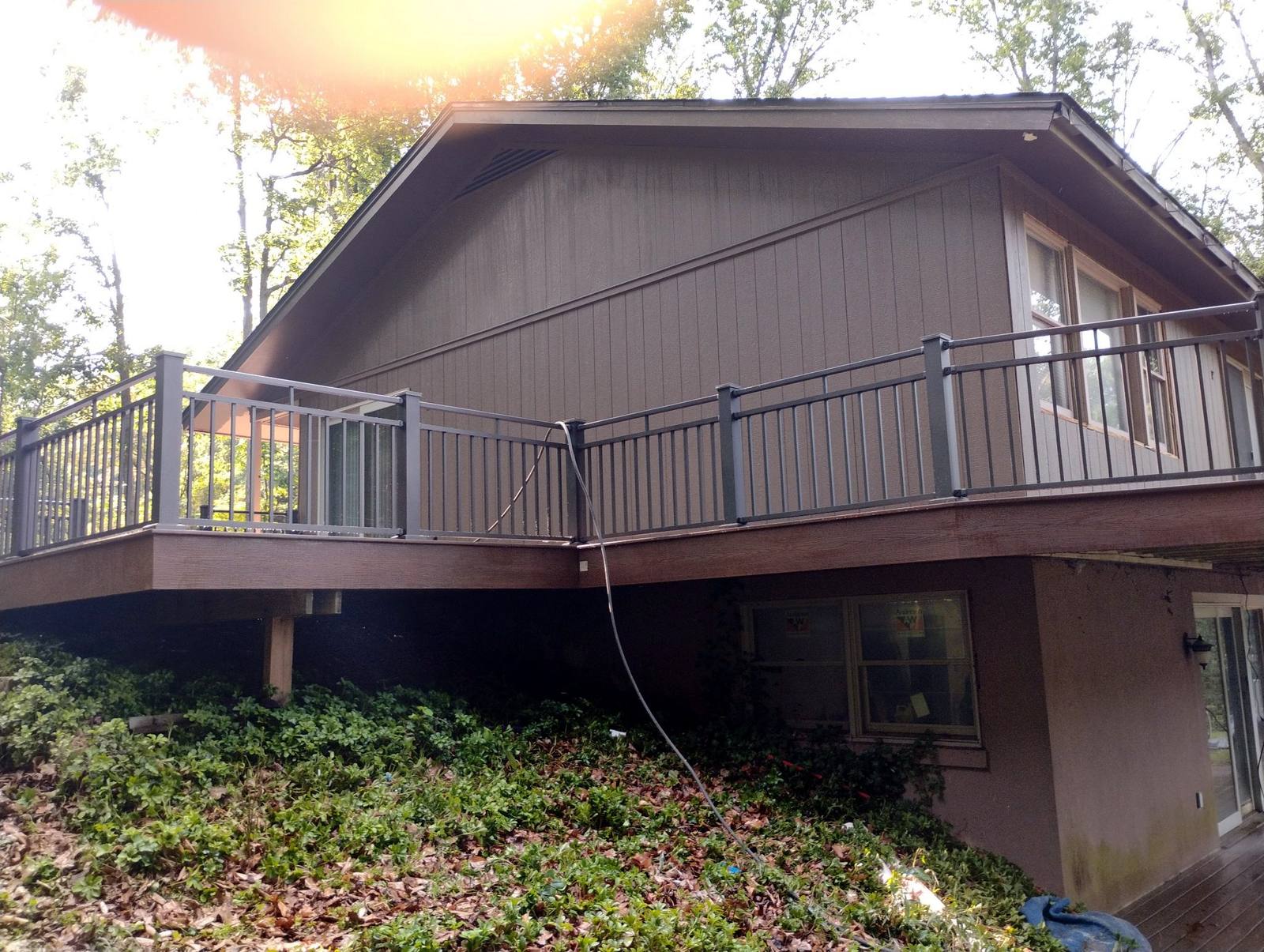 Elevated covered wood deck overlooking a wooded yard
