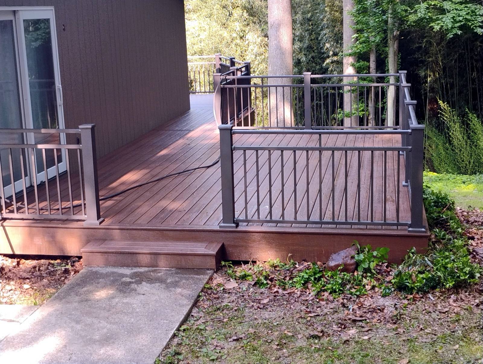 Completed deck entrance with wood railing and gate