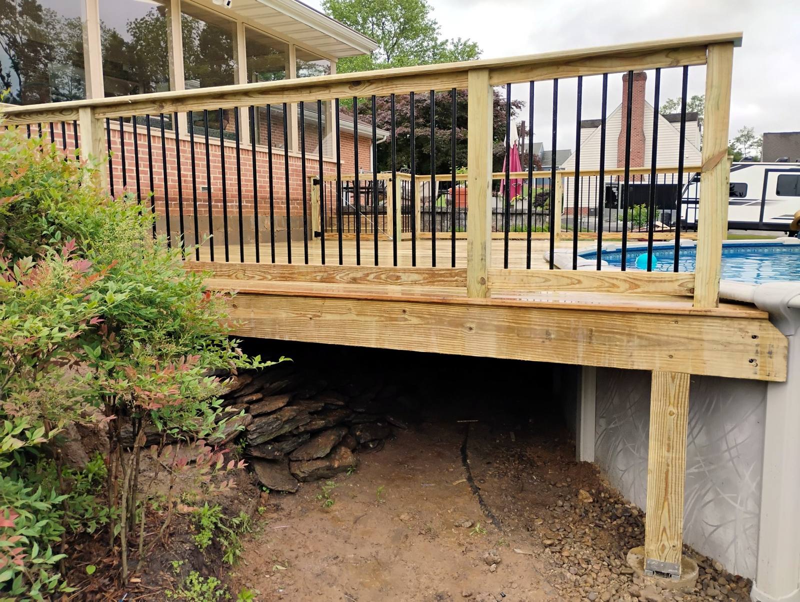 Finished pool deck and exterior staircase viewed from the yard
