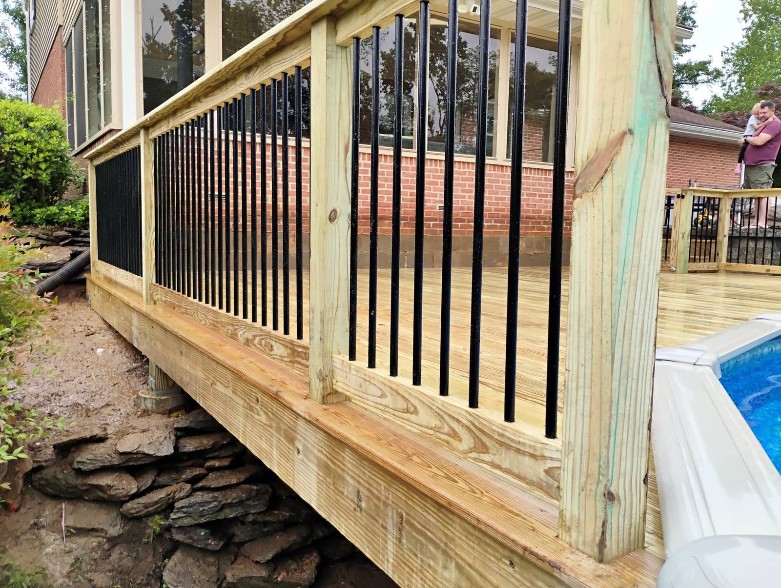 Close view of a completed poolside deck and railing