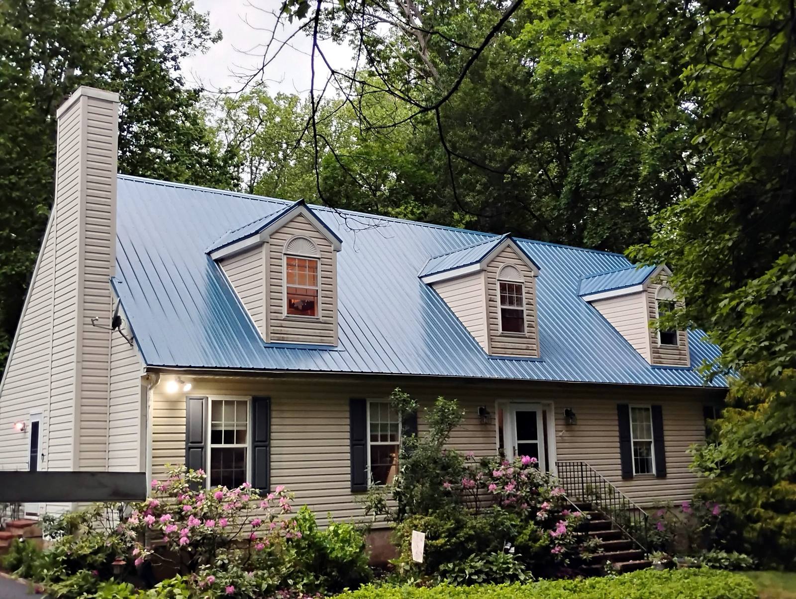 Completed stone home with dormers and landscaped front yard