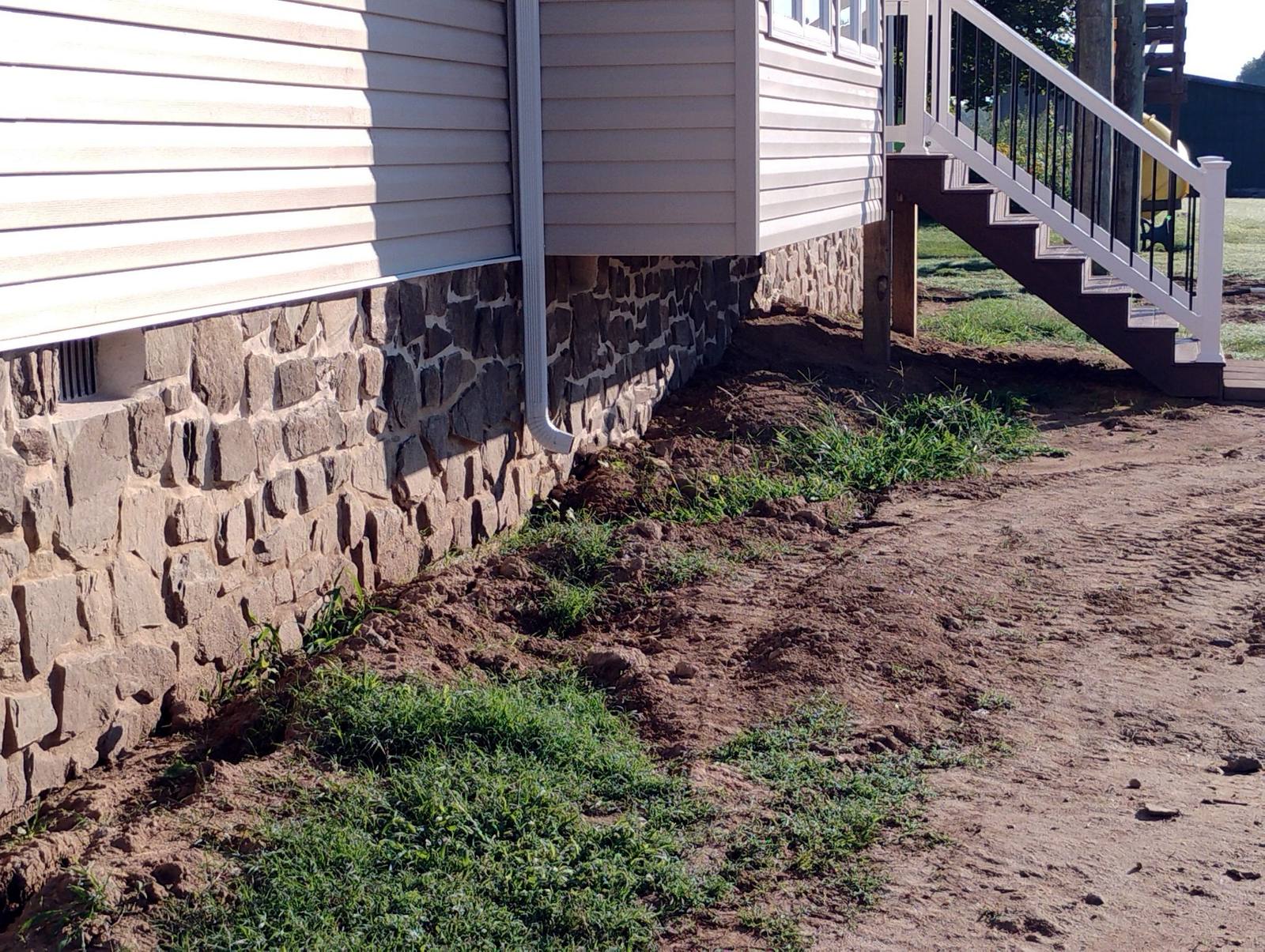 Finished stone foundation beneath light siding
