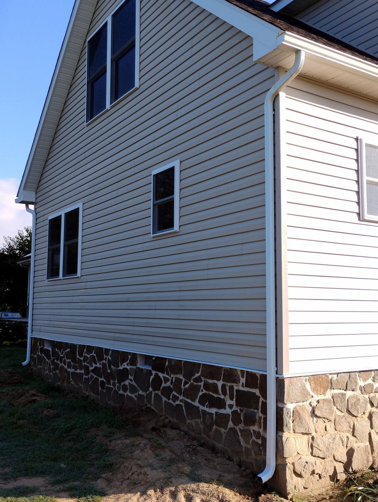 Finished siding and stone foundation on a two-story home