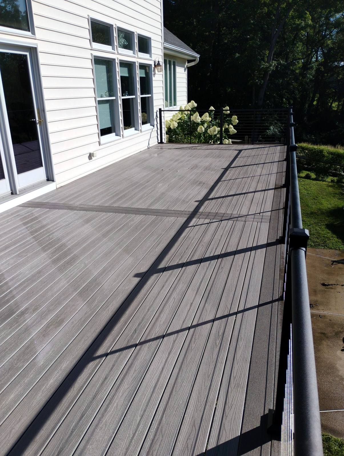 Gray composite deck surface beside a completed home