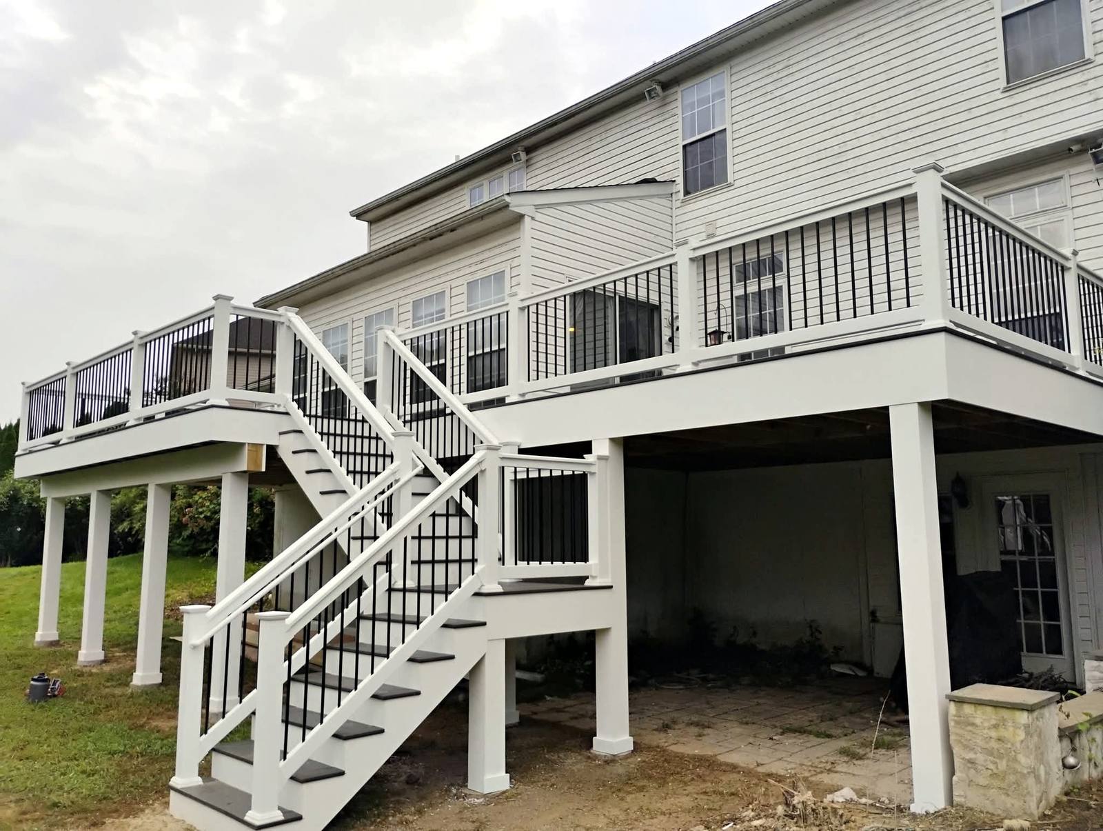 Completed white raised deck with broad exterior stairs